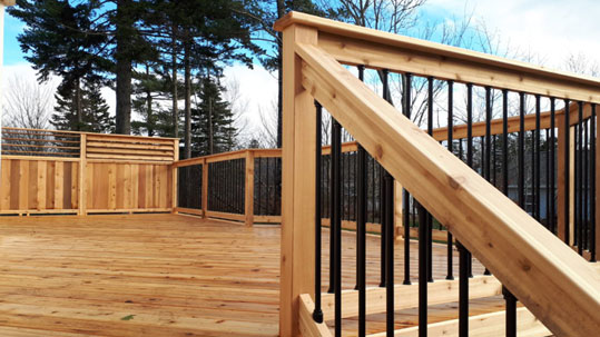 Wooden deck and railing with black metal balusters