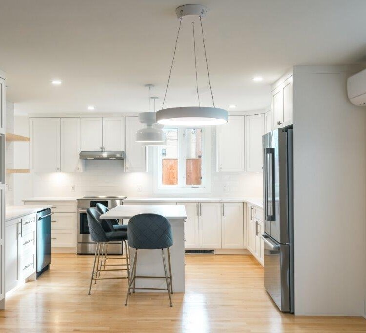 Kitchen renovation with new white cabinets, island, and hardwood floor